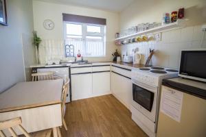 a kitchen with a table and a stove top oven at Great 3 Bedroom Chalet To Hire With In Hemsby, Great Seaside Break! Ref 18194b in Hemsby