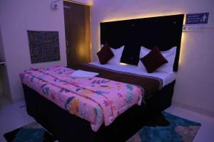 - une chambre avec un grand lit et une couette rose dans l'établissement POP Hotel Blue Star, à Bhilai