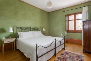 una camera con un grande letto e una finestra di I gerani rossi a Paulilatino