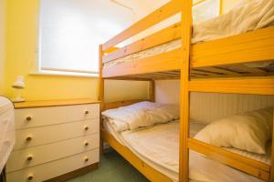 a bunk bed room with two bunk beds and a dresser at 7 Berth Chalet In Hemsby In Norfolk By The Beautiful Golden Beach Ref 18165b in Hemsby