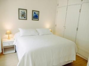 a bedroom with a white bed and a white cabinet at Pousada Morro do Elefante in Campos do Jordão
