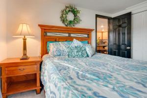 ein Schlafzimmer mit einem Bett und einem Nachttisch mit einer Lampe in der Unterkunft East Wenatchee Home with Yard and Hot Tub! in East Wenatchee