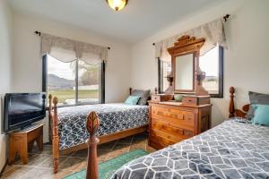 1 Schlafzimmer mit 2 Betten, einem Spiegel und einem TV in der Unterkunft East Wenatchee Home with Yard and Hot Tub! in East Wenatchee