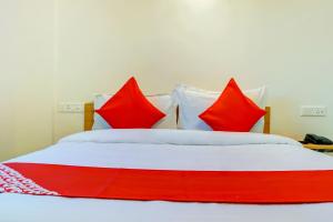 een bed met rode en witte kussens erop bij Flagship Sbk Icon Near Fun Time Multiplex in Māngvādi