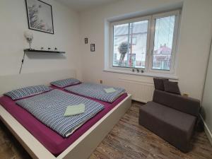 a bedroom with a bed and a chair in it at Apartmán U Jakuba in Dvůr Králové nad Labem