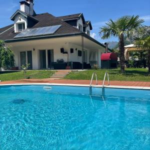 une maison avec une piscine en face d'une maison dans l'établissement Villa Mariel Lago Maggiore luxury Suite & Wellness, à Gravellona Toce