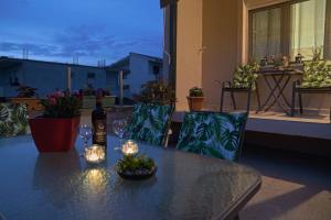 a table on a balcony with a bottle of wine and candles at Ntina's Hause in Chaïdeftón