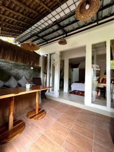 ヌサドゥアにあるSummer Homestay Baliのテーブルとベッドが備わる客室です。