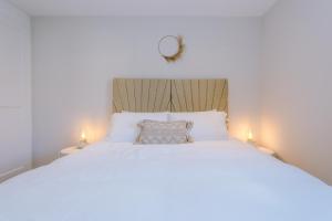 um quarto com uma cama branca e 2 candeeiros em Wild Drive Chester - Stunning cottage in CH1 with Double Parking em Chester