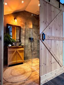 een badkamer met een douche en een houten muur bij Bezkresne- Domy w Sidorach in Jeleniewo