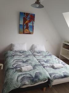 a bed in a room with a picture on the wall at MAISON AU COEUR DE LA PETITE CITE DE CARACTERE in Malestroit