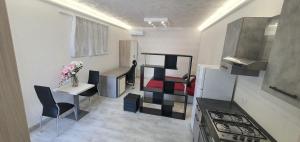 eine Küche mit einem Kühlschrank sowie einem Tisch und Stühlen in der Unterkunft alhena room in Terracina
