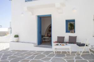 a white building with a table and a chair at Traditional Arch House Paros in Márpissa