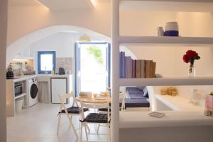 a kitchen and living room with a table and chairs at Traditional Arch House Paros in Márpissa