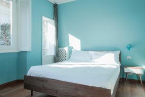 um quarto com paredes azuis e uma cama grande em Brera Apartments in San Marco em Milão