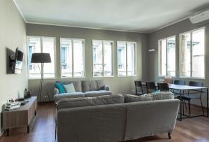 uma sala de estar com um sofá, uma mesa e janelas em Brera Apartments in San Marco em Milão