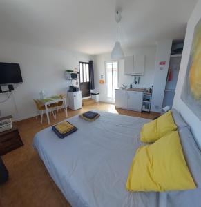 a bedroom with a large bed with yellow pillows on it at "Casa Oliveiras" studio avec terrasse et piscine in Loulé