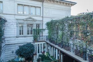 a white building with plants on a balcony at Brera Apartments in San Marco in Milan