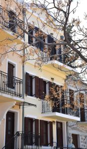 a white building with balconies and a tree at The twins house in Samothraki