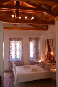 a bedroom with a large bed and two windows at The twins house in Samothraki
