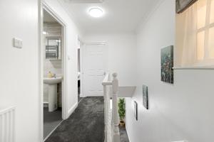 a white bathroom with a sink and a mirror at Roomy 3 bedroom house, 2 baths in Edgware
