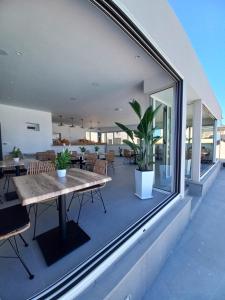 a patio with tables and chairs and a large window at En Plo Boutique Suites in Oia