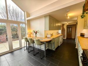 a kitchen with a table and some chairs in it at Grove House in Egremont