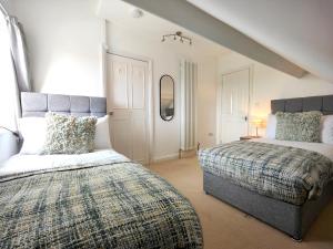 a bedroom with two beds and a mirror at Grove House in Egremont