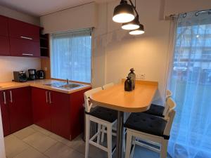 una pequeña cocina con mesa de madera y sillas en Dube YourHostHelper, en Caen