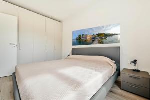 a bedroom with a bed and a painting on the wall at ApartmentsGarda - Garda31 Residence in Garda +147 photos