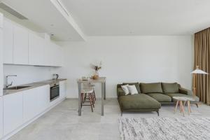 una sala de estar con un sofá y una mesa en Luštica Magnolia apartment, en Tivat