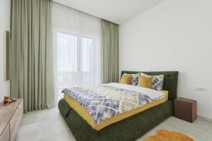 - une chambre avec un lit et une grande fenêtre dans l'établissement Luštica Bay Magnolia apartment with big terrace, à Tivat