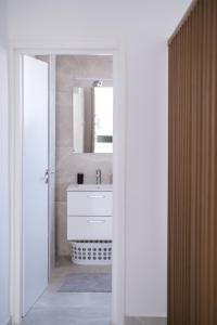 een badkamer met een witte wastafel en een spiegel bij Royal Stay Luxury Homes in Paphos City