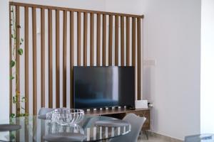 a dining room with a table and a television at Royal Stay Luxury Homes in Paphos City