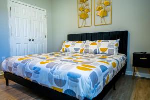 a bedroom with a bed with a blue and yellow comforter at Completely Renovated - The Art Deco Retreat in Durham