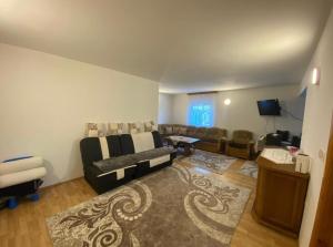 uma sala de estar com um sofá e uma televisão em Apartmani Piramida Mjeseca i Sunca em Visoko