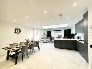 a dining room and kitchen with a table and chairs at Modern and spacious, family house. in Luton