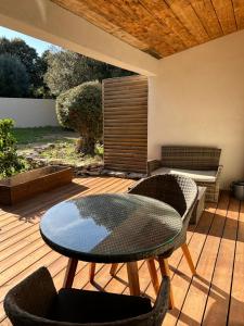 a patio with a table and chairs on a deck at Résidence Alba in Bonifacio