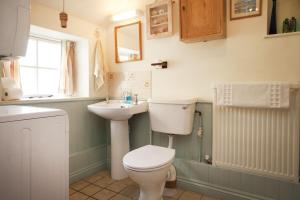 een badkamer met toilet en wastafel bij Honey Barrel Cottage in Stiffkey