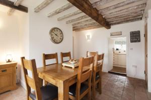a dining room with a wooden table and chairs at Harvey Cottage in Barney