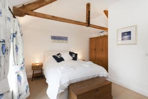 a bedroom with a white bed and a wooden cabinet at Harvey Cottage in Barney