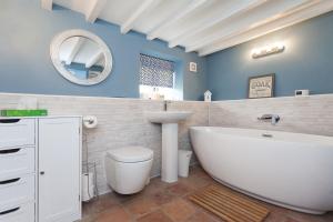 Barney的住宿－Harvey Cottage，带浴缸、卫生间和盥洗盆的浴室