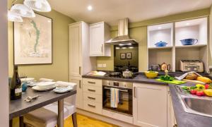 a kitchen with white cabinets and a sink and a counter at Barn End in Ambleside +9 photos