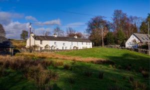 a white house on top of a grassy hill at Barn End in Ambleside