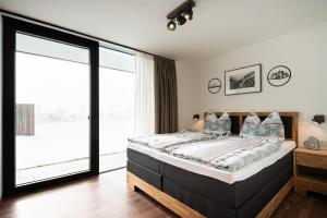 1 dormitorio con cama y ventana grande en Apartment GIDI und LISL, en Bramberg am Wildkogel