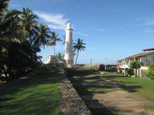 a lighthouse on top of a hill with palm trees at Anara Villa in Unawatuna