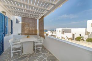 balcón con mesa, sillas y vistas al océano en Piperi-2 Bedroom home, en Naousa