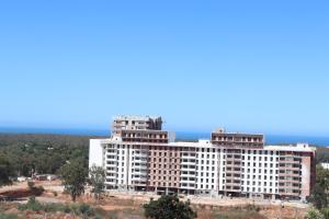 un grand bâtiment blanc au sommet d'une colline dans l'établissement Privat Apartments Prestigia Hay Riad, à Rabat