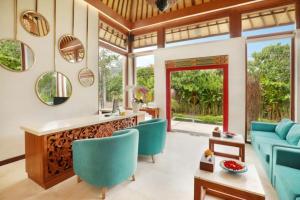 a living room with blue chairs and a counter at Aksari Villa Seminyak by Ini Vie Hospitality in Seminyak