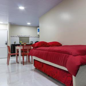 een slaapkamer met 2 bedden en een eetkamer met een tafel bij Mensú Grand Hotel in Puerto Iguazú